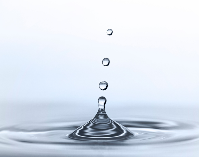 Goccia d'acqua al momento dell'impatto con corona di schizzi in risalita